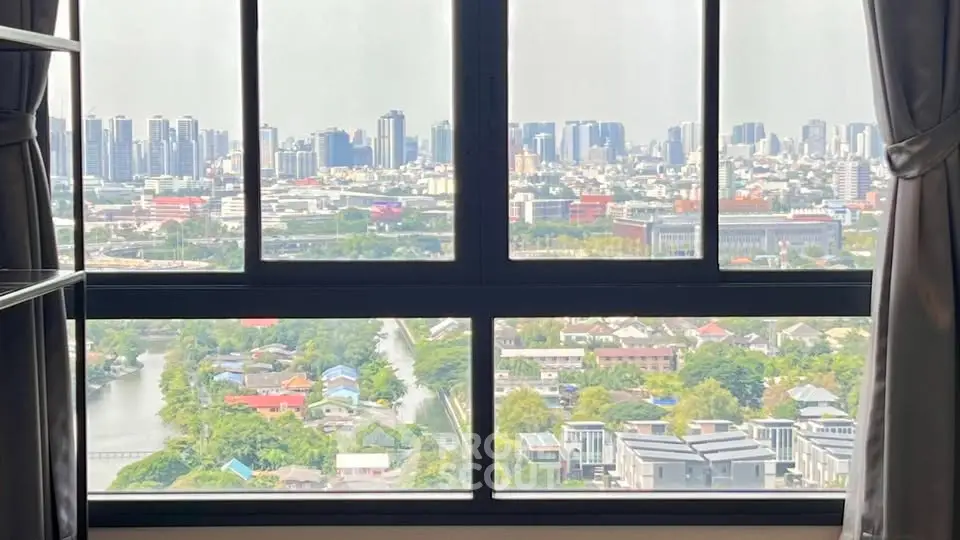 Stunning cityscape view from high-rise apartment window, showcasing urban skyline and lush greenery.