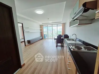 Modern open-layout living room with kitchen and balcony view