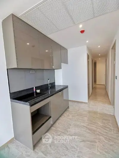 Modern kitchen with sleek cabinetry and granite countertops in a spacious apartment.