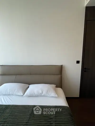 Modern bedroom with minimalist design and cozy bedding in a stylish apartment.