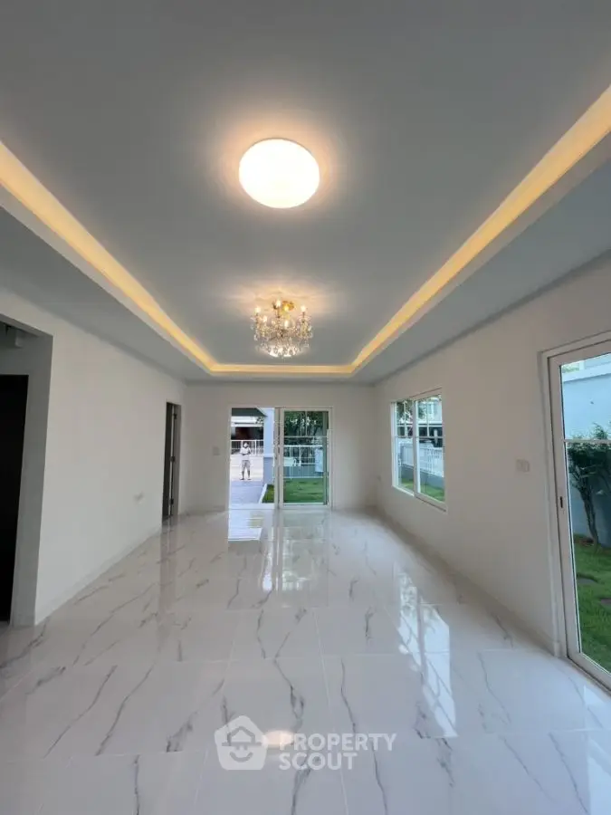 Spacious modern living room with elegant lighting and large windows.