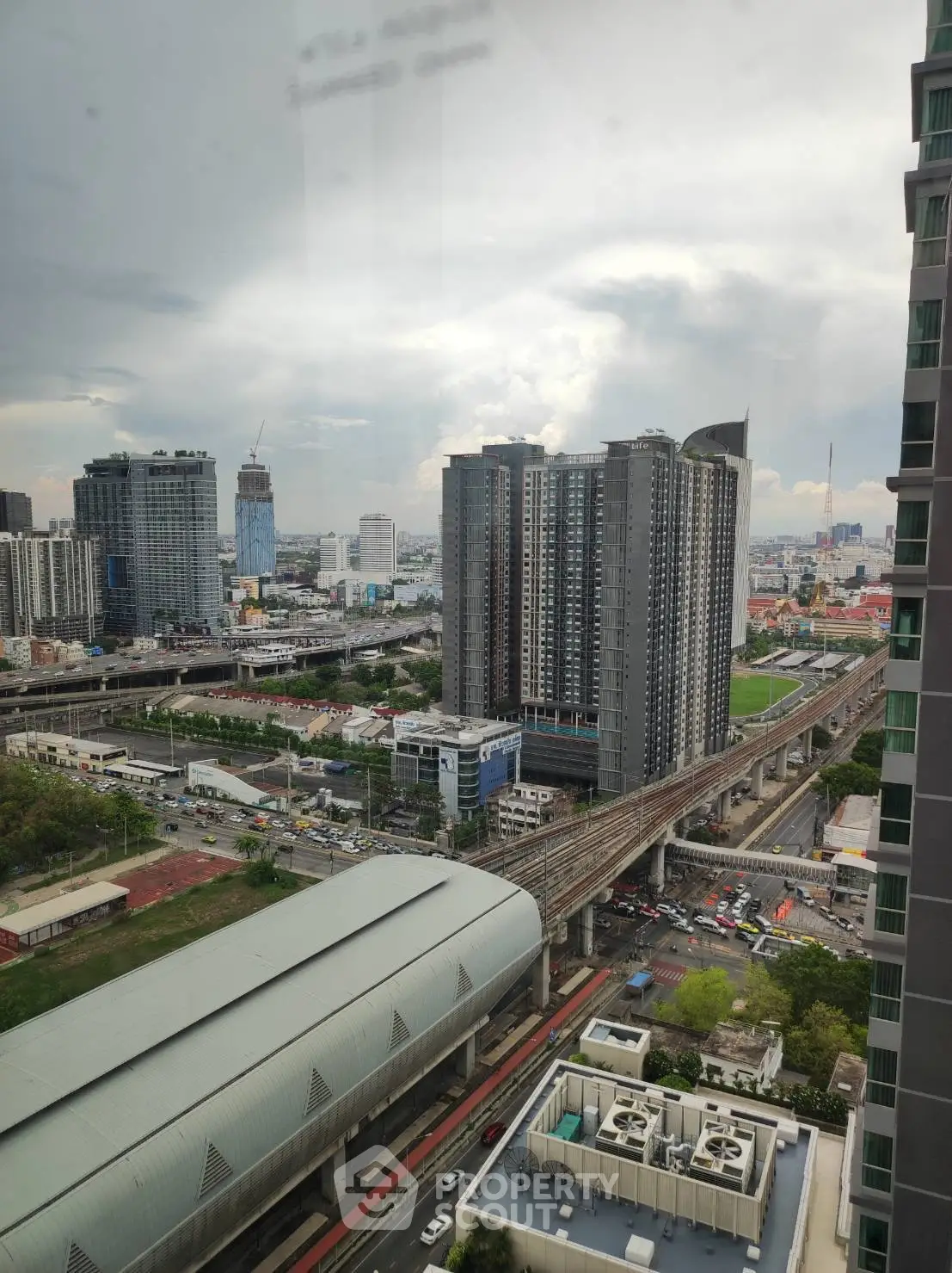 Stunning cityscape view from high-rise building showcasing urban skyline and transportation infrastructure.
