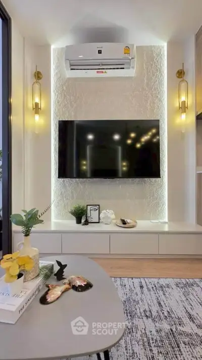 Modern living room with stylish decor, wall-mounted TV, and air conditioning unit.