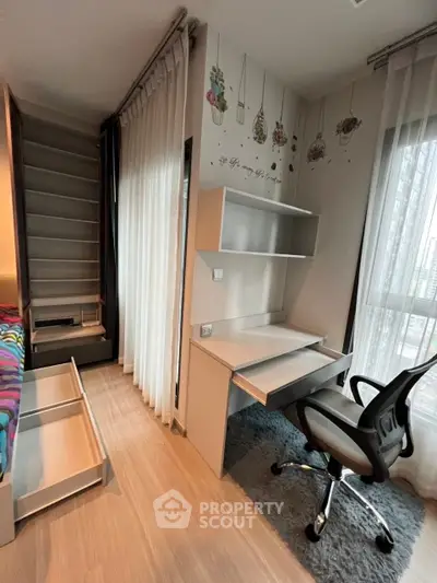 Modern study room with desk, chair, and decorative wall art in a bright apartment.