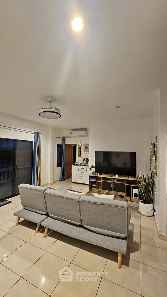 Spacious living room with modern decor and large TV setup