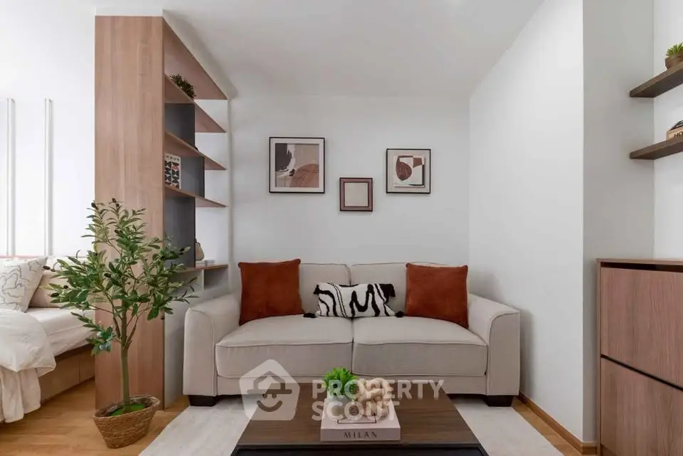 Modern living room with stylish decor and cozy seating area, featuring elegant shelving and artwork.