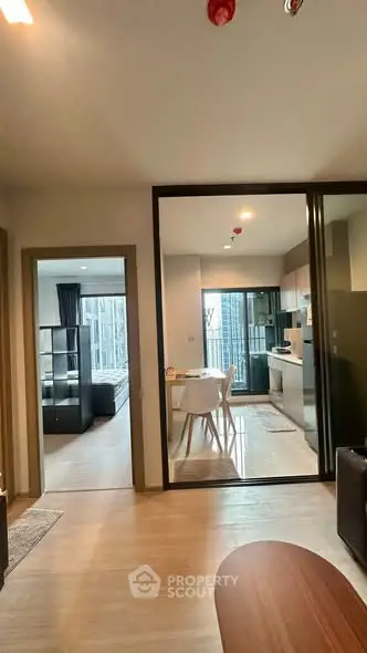 Modern open-plan apartment with kitchen and living area, featuring sleek design and natural light.