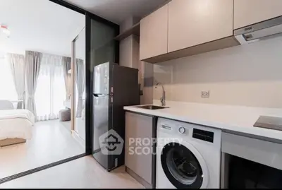 Modern apartment kitchen with washing machine and open layout to bedroom