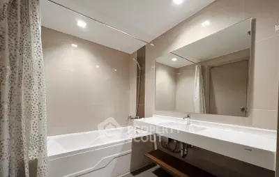 Modern bathroom with sleek design featuring bathtub and large mirror.