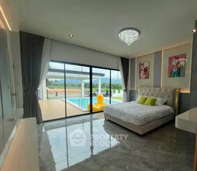 Luxurious bedroom with pool view and modern decor in a stunning real estate property.