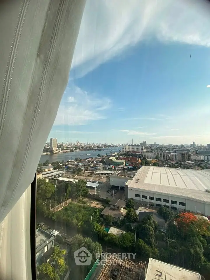 Stunning cityscape view from high-rise window overlooking river and skyline, perfect for urban living.