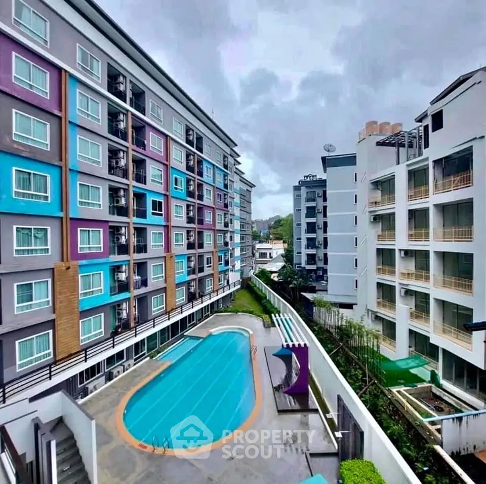 Modern apartment complex with vibrant facade and inviting swimming pool