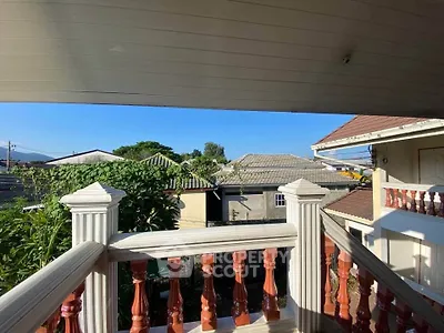Charming balcony view with classic railing overlooking neighborhood rooftops.