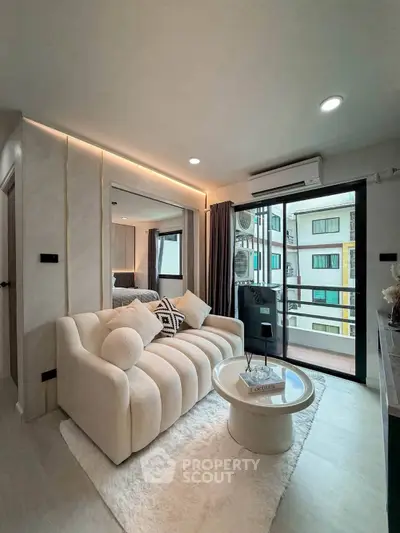Modern living room with cozy sofa, stylish decor, and balcony view in urban apartment.