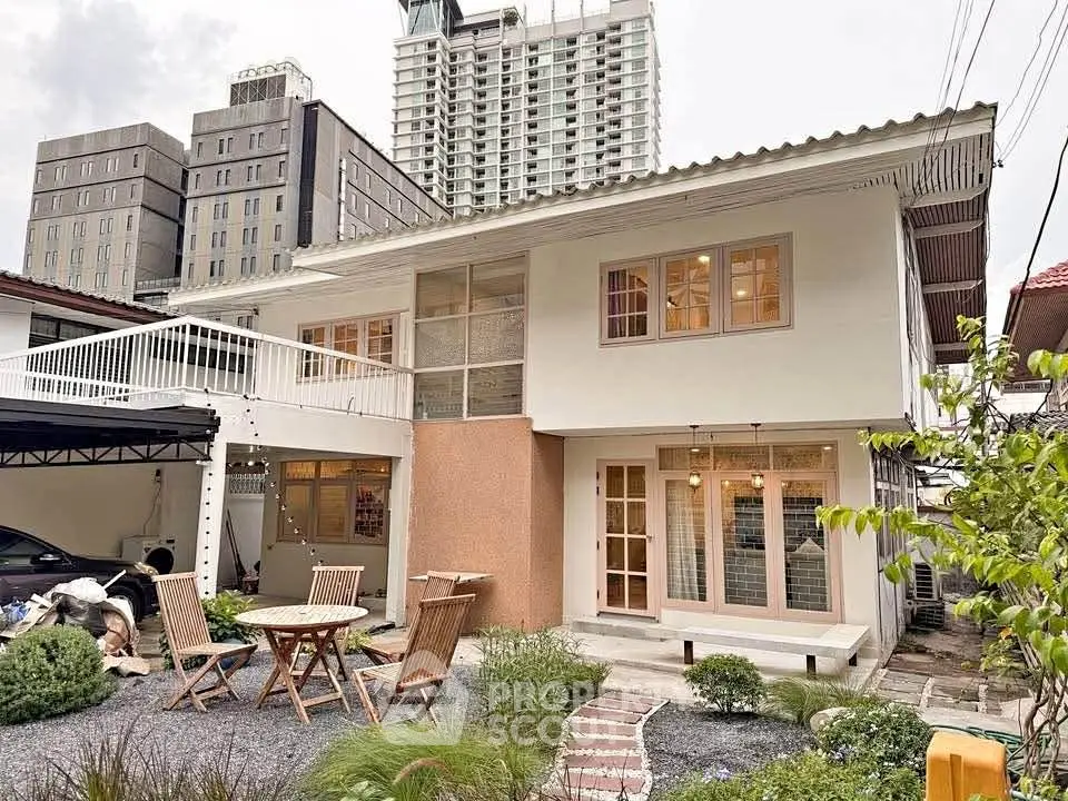 Charming two-story house with modern design and spacious outdoor seating area.