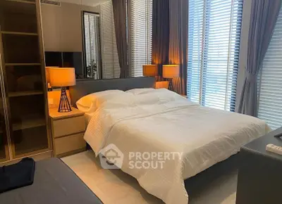 Modern bedroom with stylish lighting and large windows for natural light.