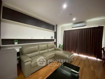 Modern living room with sleek leather sofa and stylish shelving, perfect for relaxation.