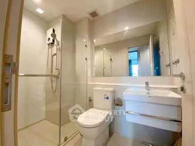 Modern bathroom with glass shower and sleek fixtures in a contemporary apartment.
