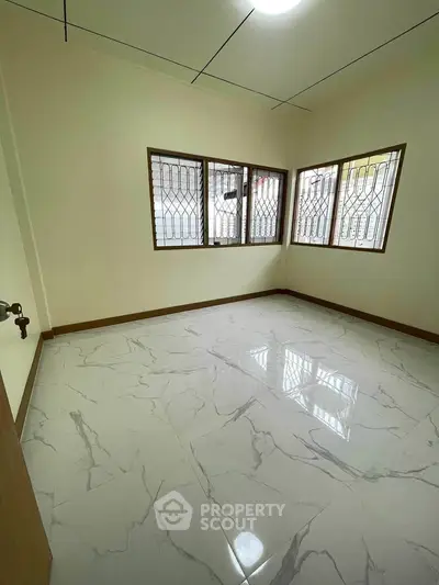Spacious empty room with large windows and marble flooring, ideal for customization.