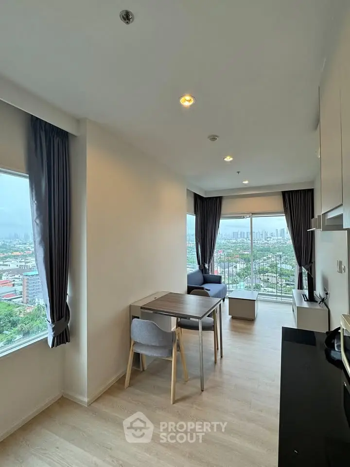 Modern apartment with stunning city view and open layout dining area, featuring large windows and sleek furnishings.
