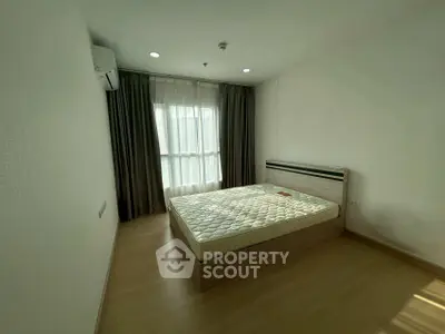 Spacious bedroom with large window and modern minimalist design.