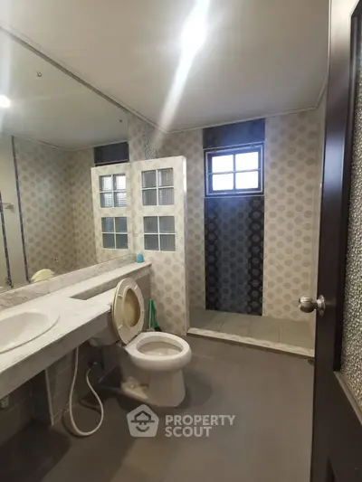 Spacious bathroom with modern fixtures and stylish tile design, featuring a large mirror and walk-in shower.