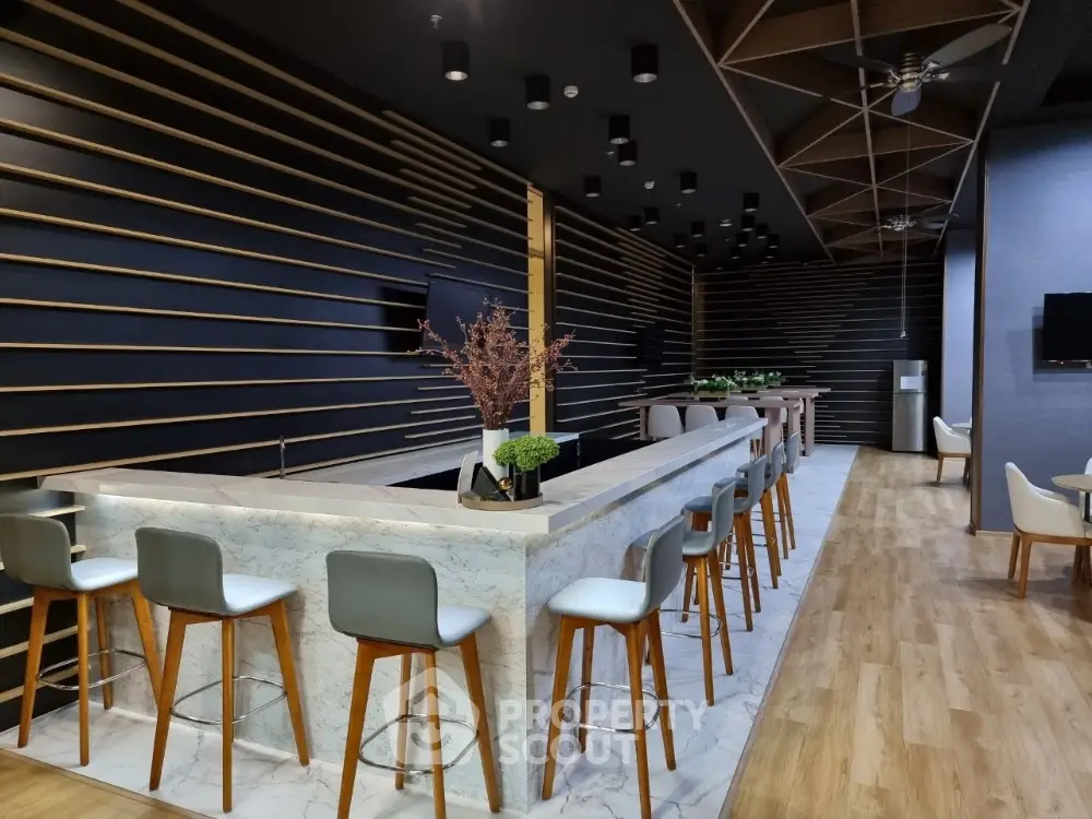 Modern communal area with stylish bar seating and contemporary design elements.