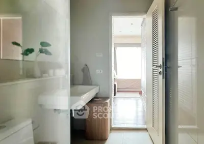 Modern bathroom with sleek design leading to a bright bedroom, showcasing contemporary living.