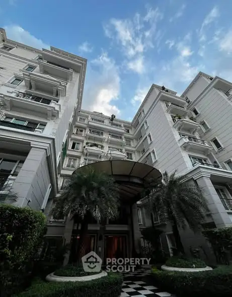 Elegant residential building with lush greenery and grand entrance