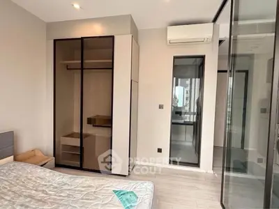 Modern bedroom with sleek wardrobe and air conditioning in a stylish apartment.