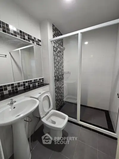 Modern bathroom with sleek shower and stylish black and white tiles