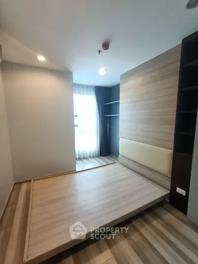 Modern minimalist bedroom with wooden flooring and built-in shelves