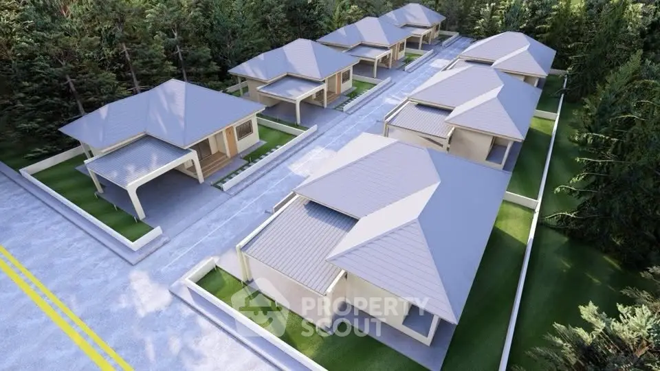 Aerial view of modern residential complex with lush greenery and spacious driveways.