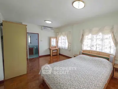 Spacious bedroom with elegant decor and natural light, featuring a comfortable bed and stylish furnishings.