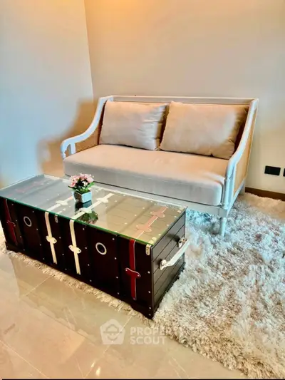 Stylish living room with elegant sofa and unique trunk coffee table on plush rug.