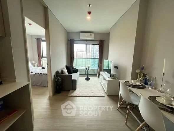 Modern apartment interior with open living and dining area, featuring a cozy balcony view.