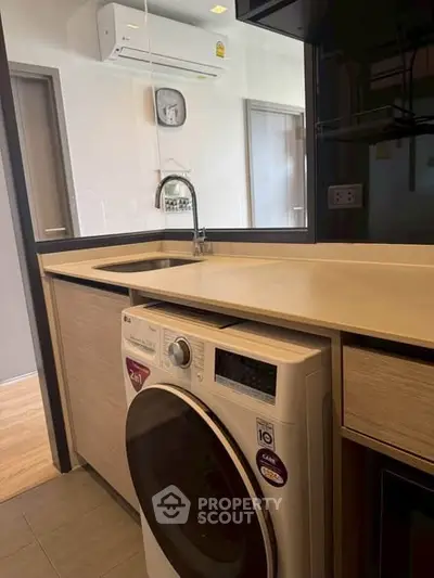Modern kitchen with built-in washing machine and sleek countertops