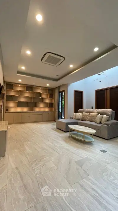 Spacious modern living room with elegant built-in shelving and cozy sectional sofa.