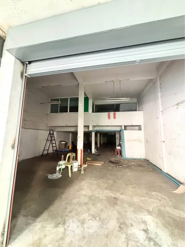 Spacious industrial warehouse with high ceilings and mezzanine level, ideal for storage or business operations.