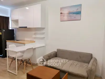 Modern open-layout kitchen and living area with sleek furniture and bright decor.