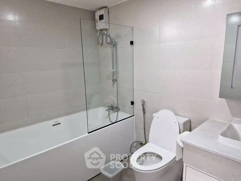 Modern bathroom with sleek design featuring bathtub and shower combo, ideal for contemporary living.