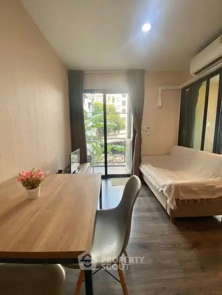 Cozy living room with balcony view, modern furniture, and natural light.