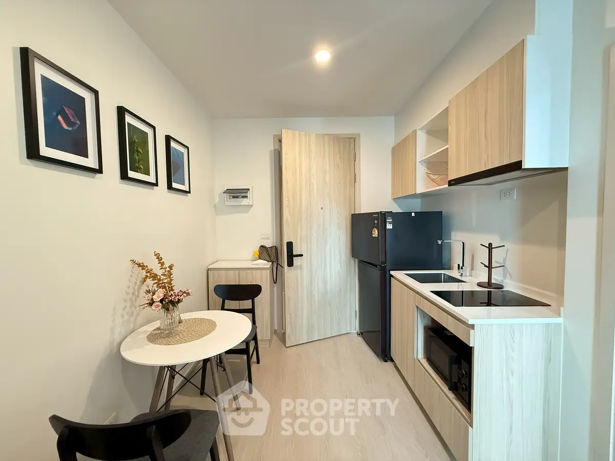 Modern kitchen with sleek design, featuring compact dining area and stylish decor.