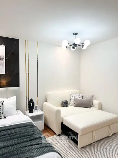 Modern bedroom with stylish decor and cozy seating area, perfect for relaxation and comfort.