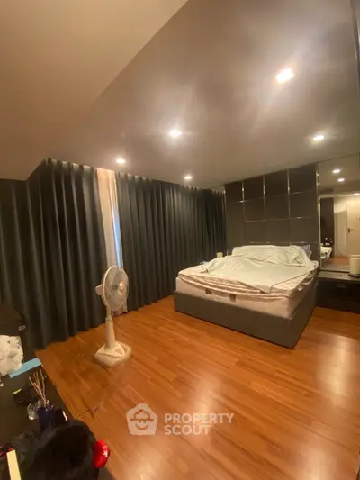 Spacious bedroom with modern decor and wooden flooring