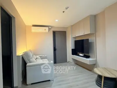 Modern living room with cozy sofa and wall-mounted TV in stylish apartment.
