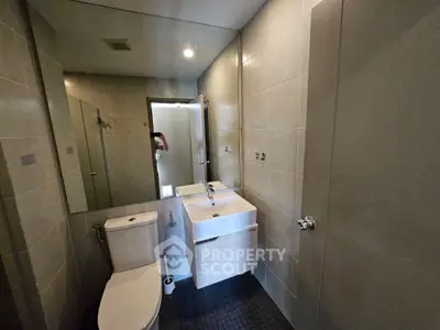 Modern bathroom with sleek fixtures and large mirror