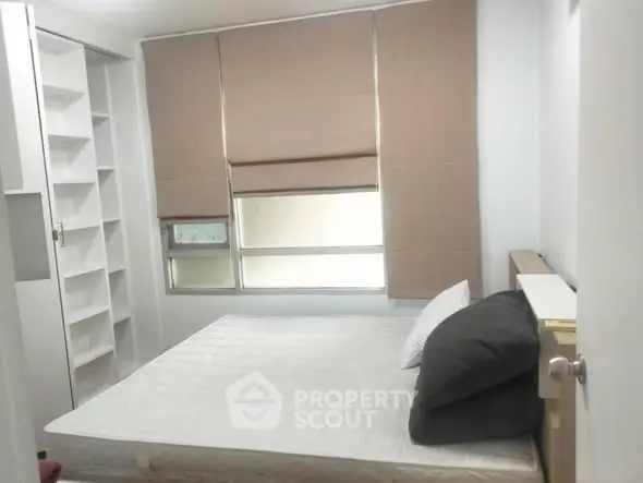 Cozy bedroom with minimalist design, featuring a comfortable bed and ample storage space.