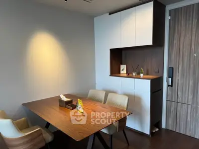Modern dining area with elegant wooden table and stylish chairs in a contemporary apartment.