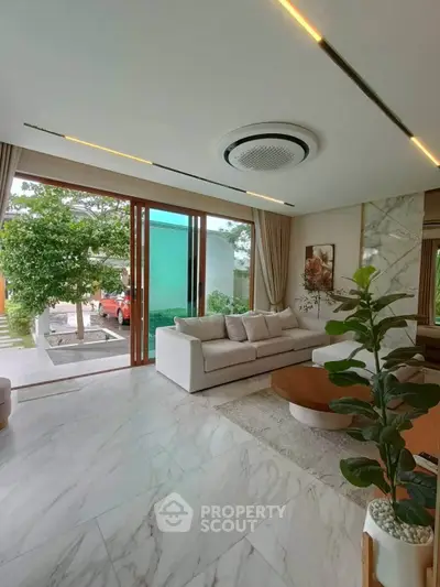 Luxurious living room with modern decor, large windows, and elegant marble flooring.